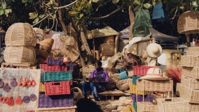 Cestos e outros artesanatos coloridos expostos para venda em uma feira ao ar livre.